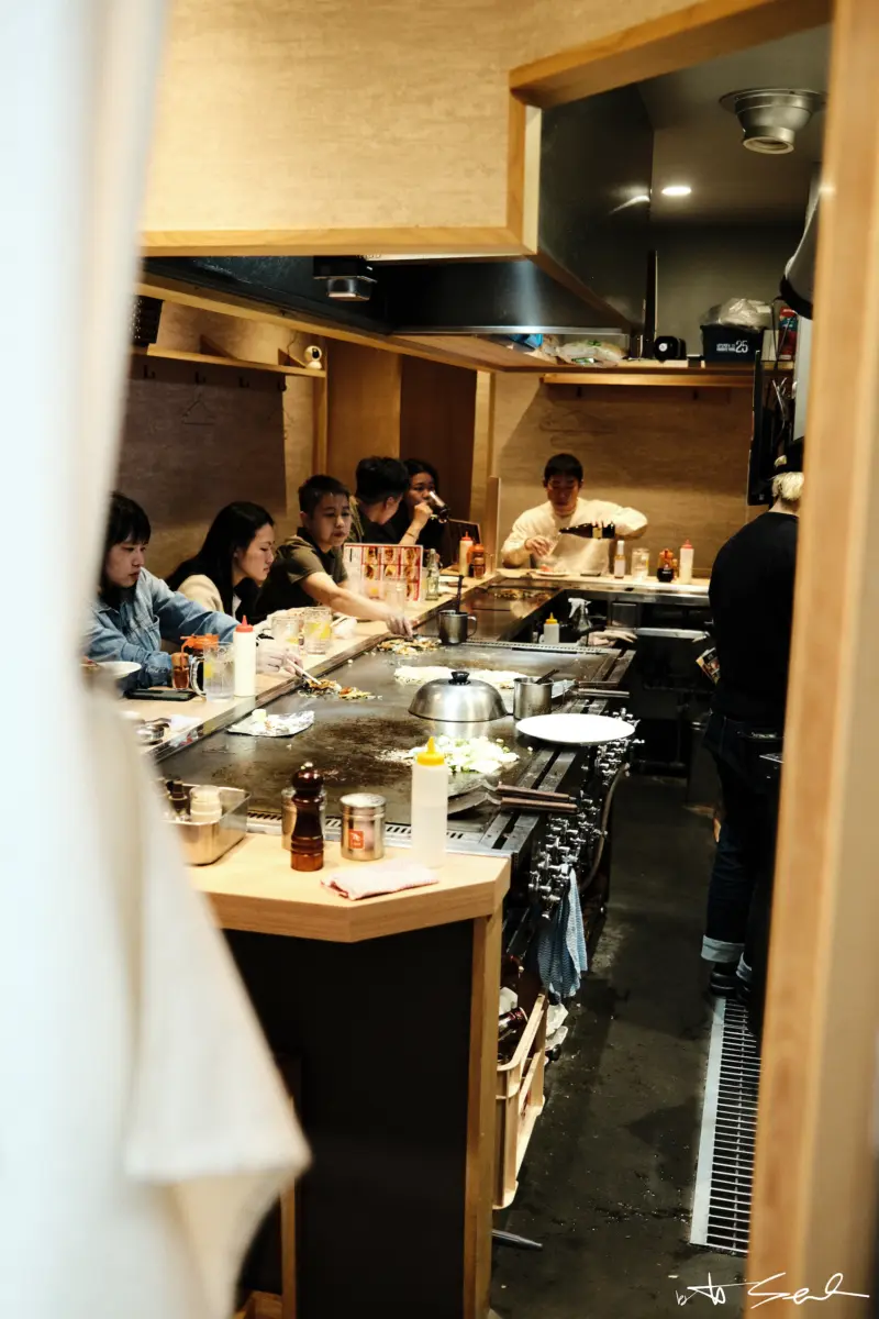 Gäste an der Theke eines kleinen Teppanyaki-Restaurants