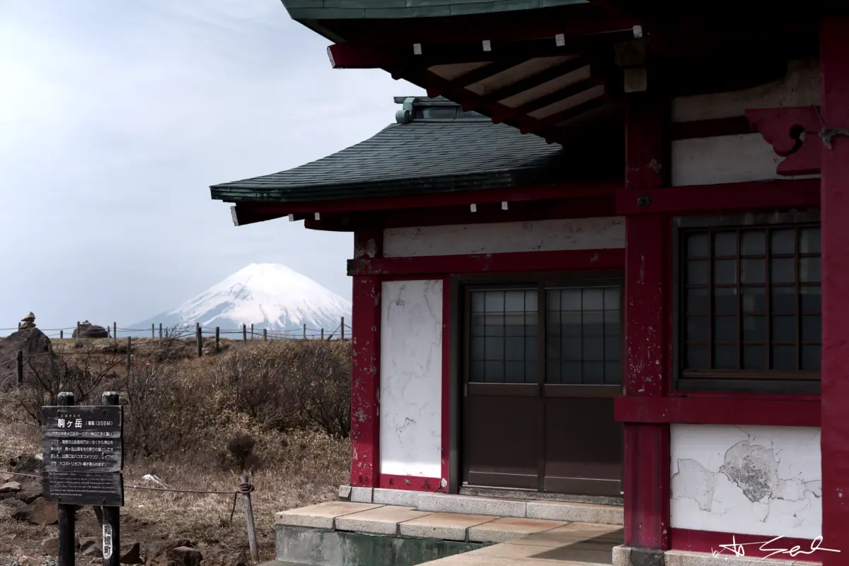 Rotes Tempelgebäude mit dem schneebedeckten Fuji im Hintergrund