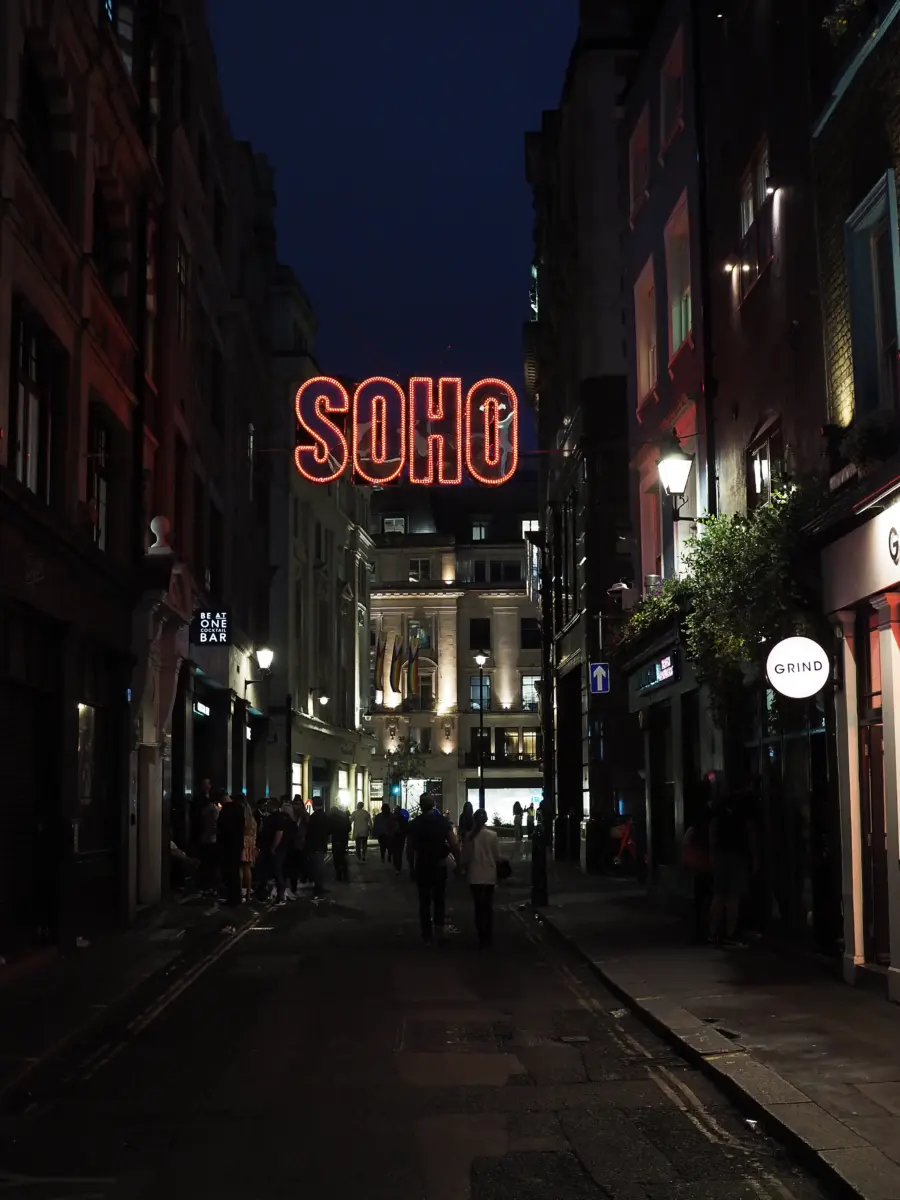 Nächtliche Gasse in Soho mit leuchtendem Neon-Schriftzug