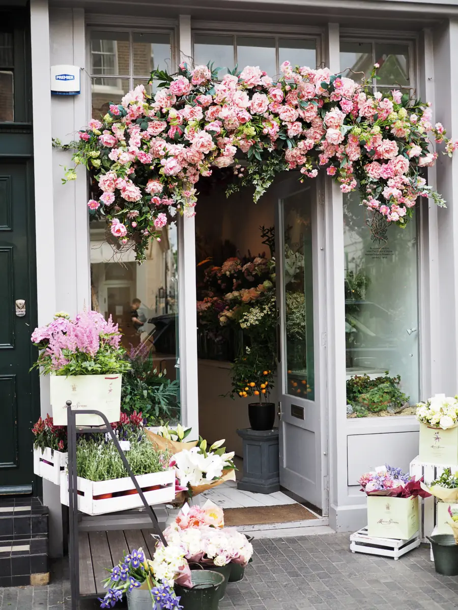 Blumenladen mit Eingang unter einem Bogen aus rosa Rosen
