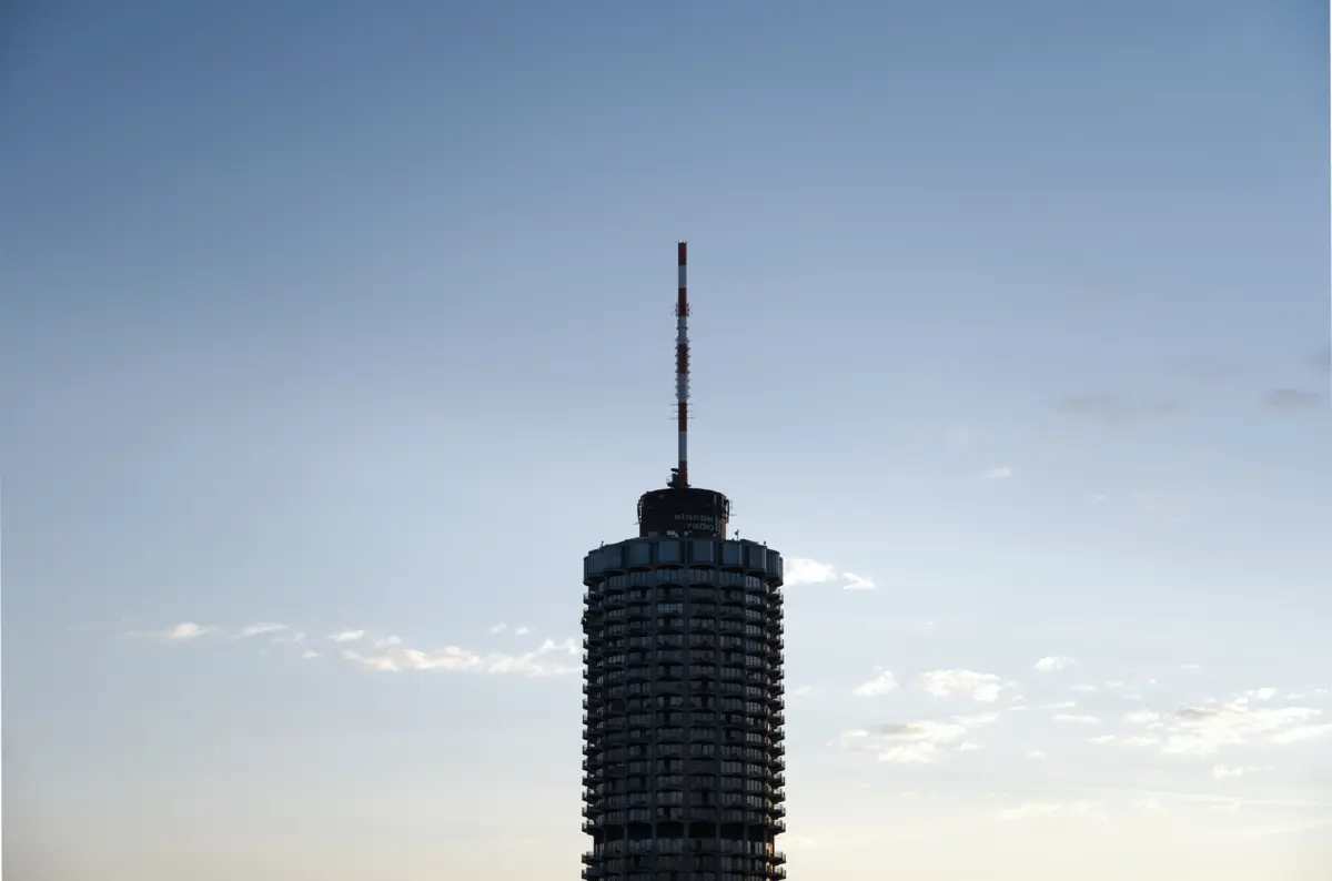 Silhouette eines runden Hochhausturms vor hellem Himmel