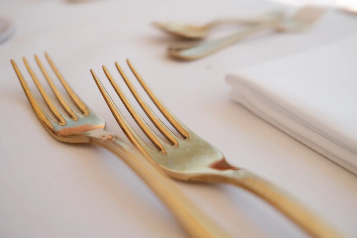 Goldenes Besteck auf weißer Tischdecke