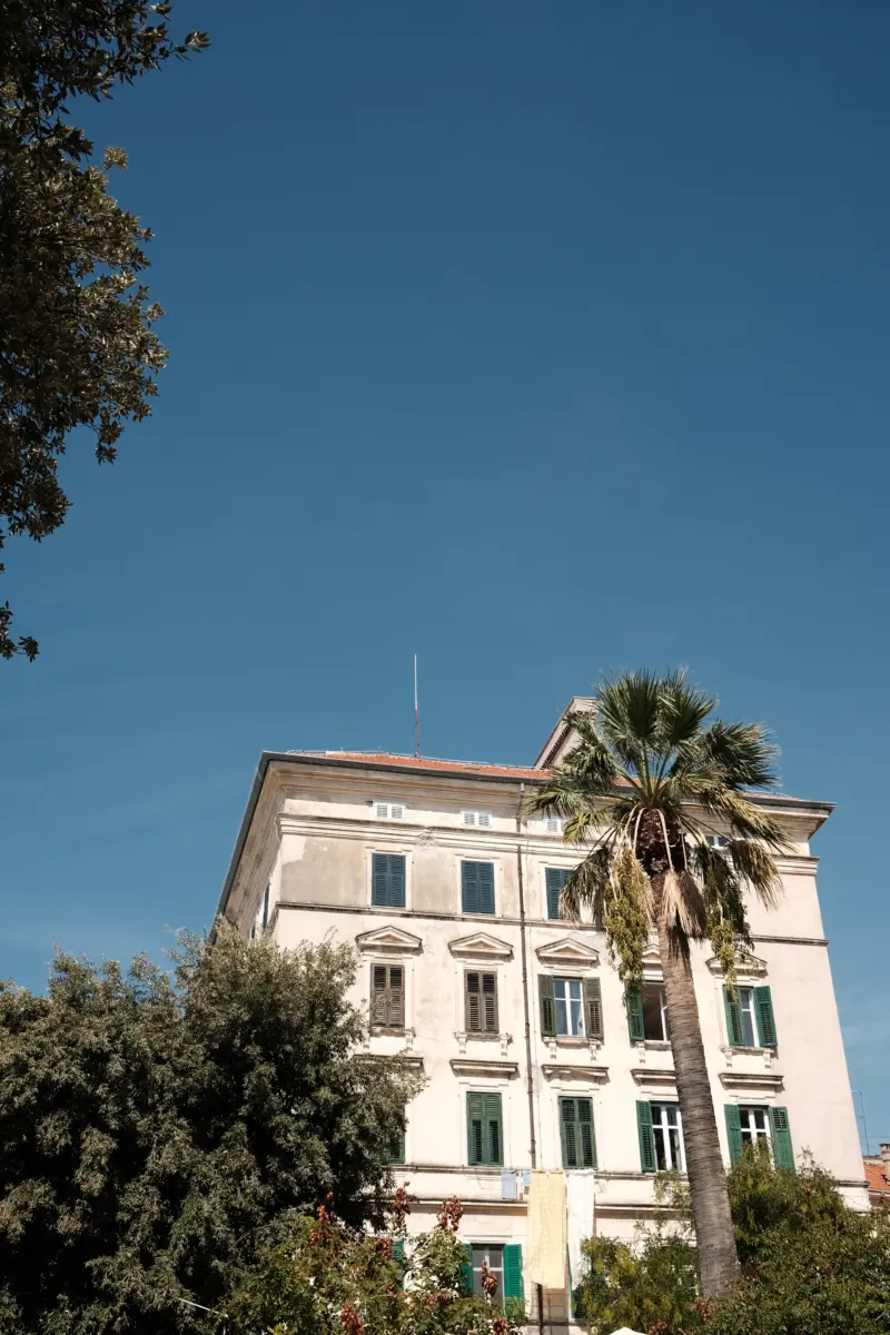 Altes Gebäude mit Palme unter tiefblauem Himmel