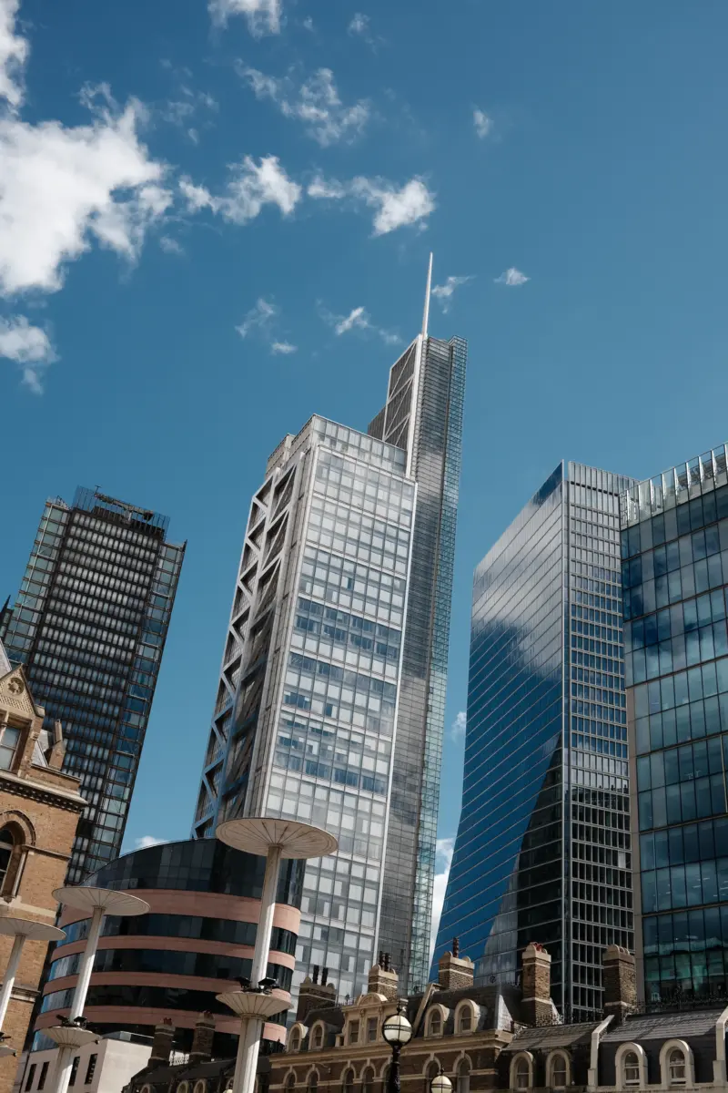 Hochhäuser der City of London vor blauem Himmel mit Wolken