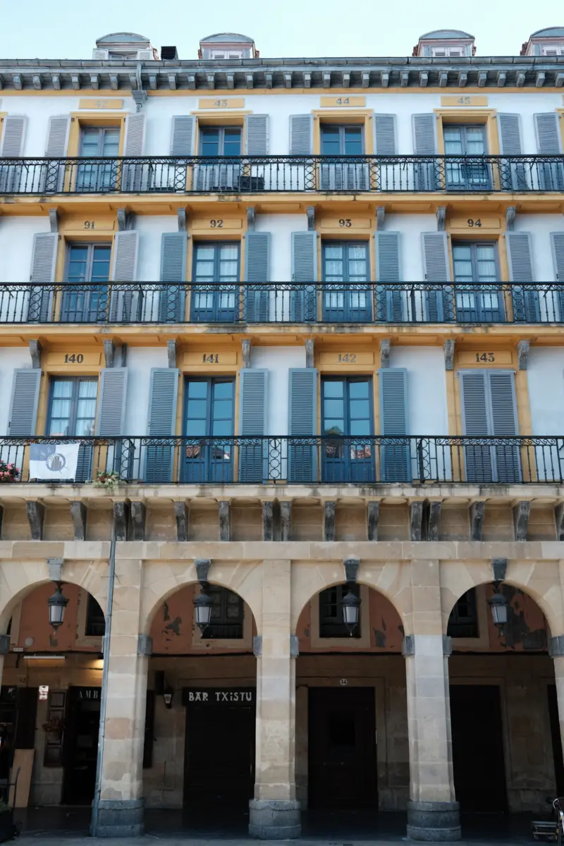 Fassade mit nummerierten Balkonen und Arkaden an der Plaza de la Constitución