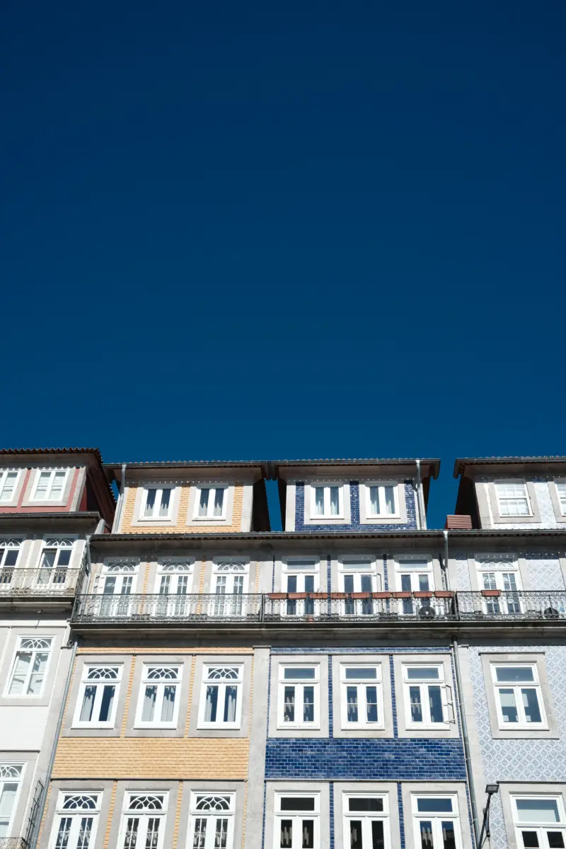 Häuserzeile mit bunten Kachelfassaden vor tiefblauem Himmel