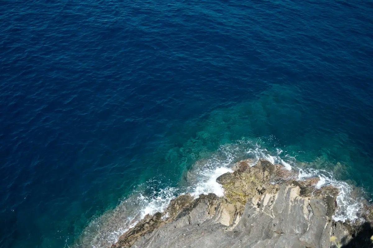 Felsen im tiefblauen Meer von oben